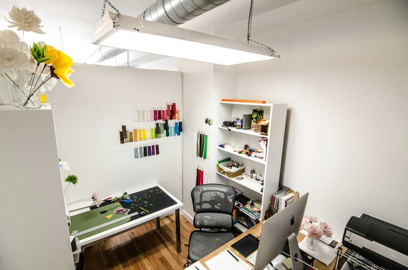 Elegant and organized creative workspace featuring design materials and office equipment, perfect for innovative work.