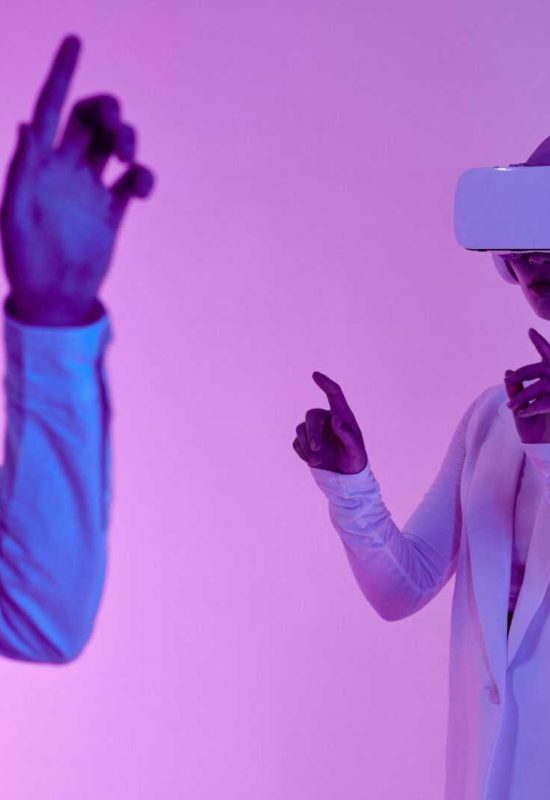 Two adults using VR headsets in a studio with vibrant lighting, depicting futuristic technology.